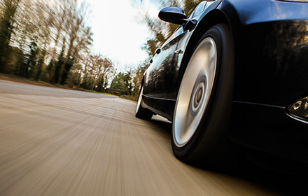 Side View of Car Speeding Down the Road After Alledged Crime