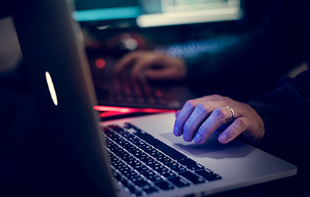 Close-Up of Hands on Laptop Keyboard To Represent the Severity of Internet Crimes