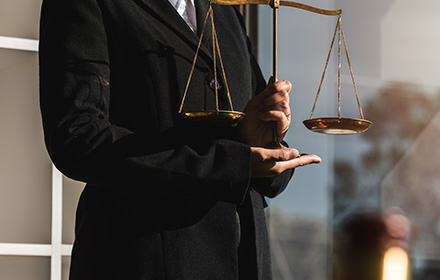 Defense Attorney Holding Scales of Justice To Represent the Severity of a Felony Charge